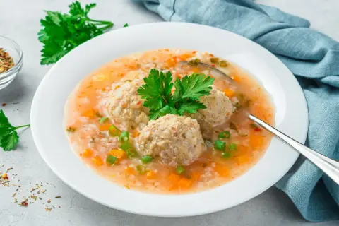 Pyszna zupa z klopsikami i ryżem, z marchewką i zieloną cebulką. Idealna odpowiedź na pytanie: jaka zupa na obiad?